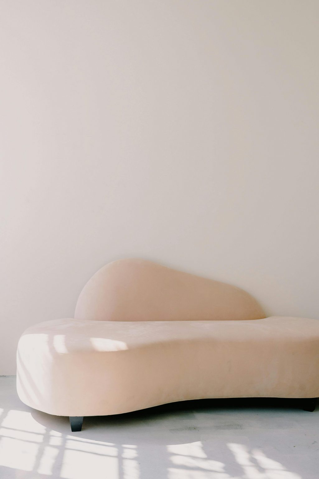 Elegant beige sofa in a minimalist setting with ample copyspace and soft shadows.